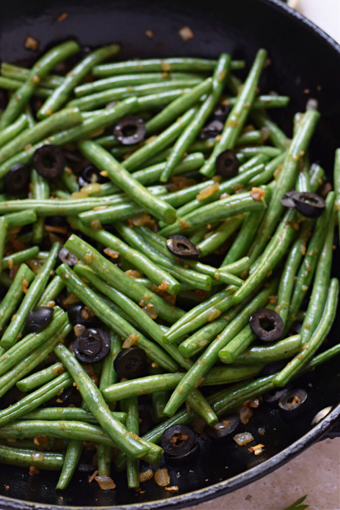 Close up of green beans and black olives.