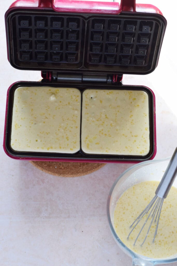 Making waffles in a waffle maker.