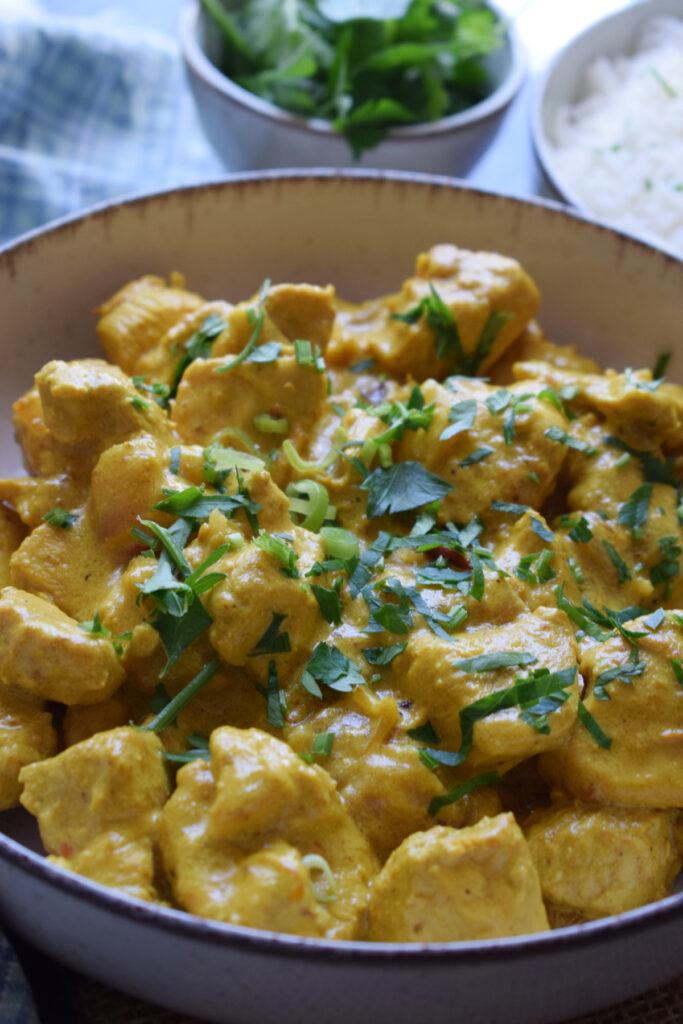 Close up of creamy chicken masala in a bowl.