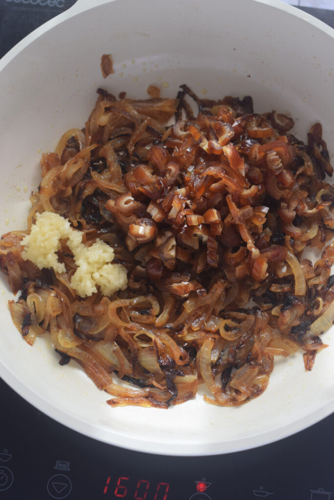 Adding dates and garlic to onions in a skillet.