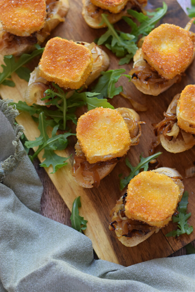 Goat cheese bruschetta on a wooden board.