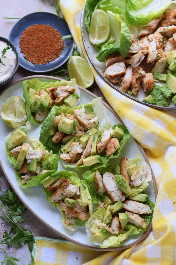 Chicken and avocado lettuce wraps on a white platter.
