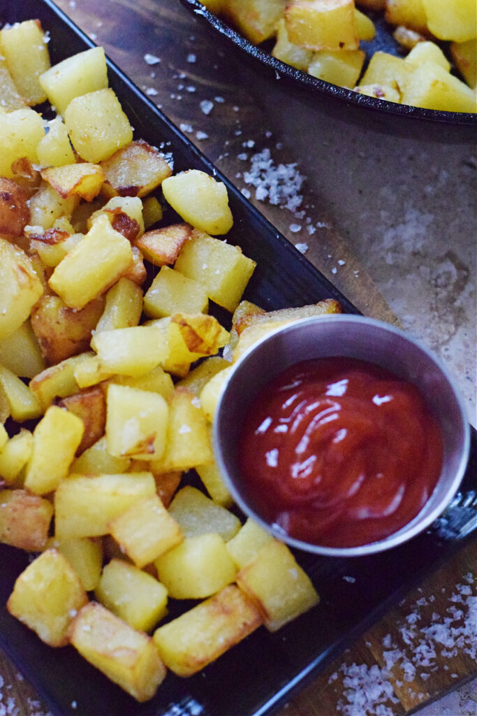 Skillet country fries with ketchup.