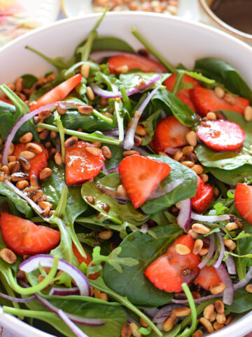 Close up of a spinach and strawberry salad.