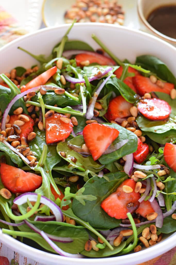Close up of a spinach and strawberry salad.