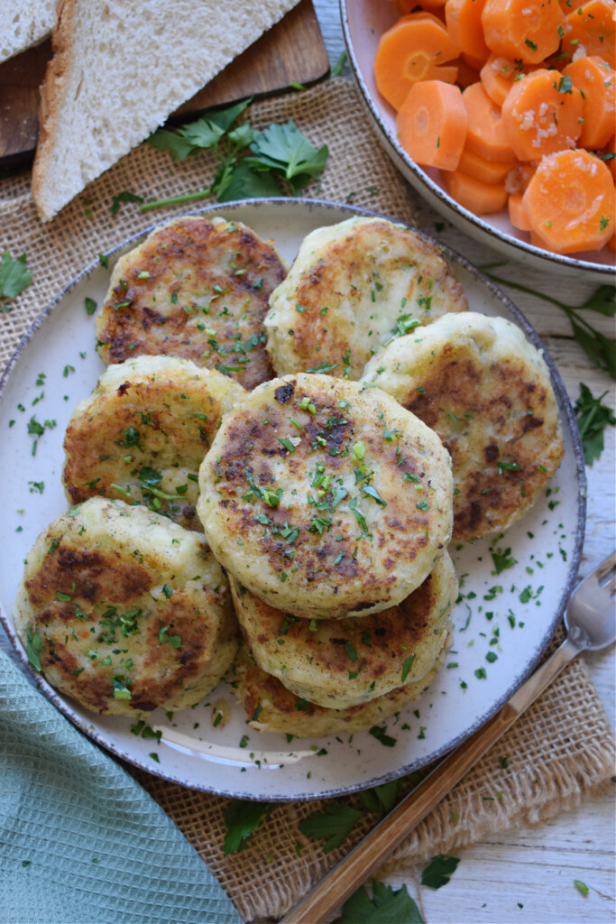 Cod cakes on a plate with carrots.