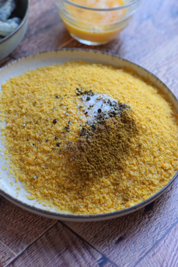 Bread crumbs on a plate with seasonings.