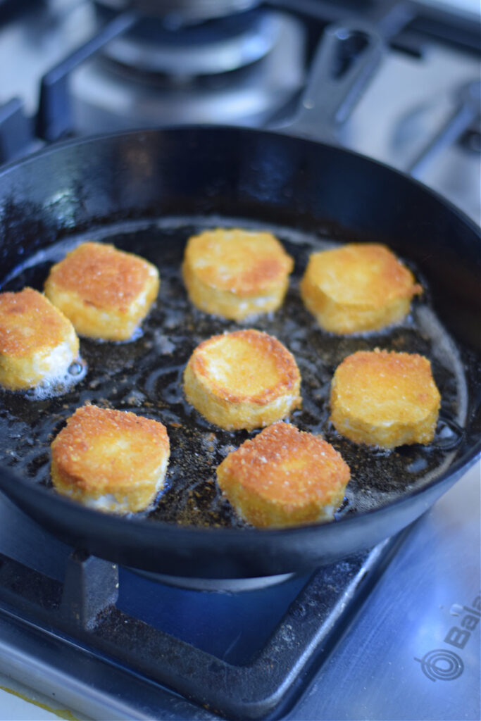 Frying goat cheese in a skillet.