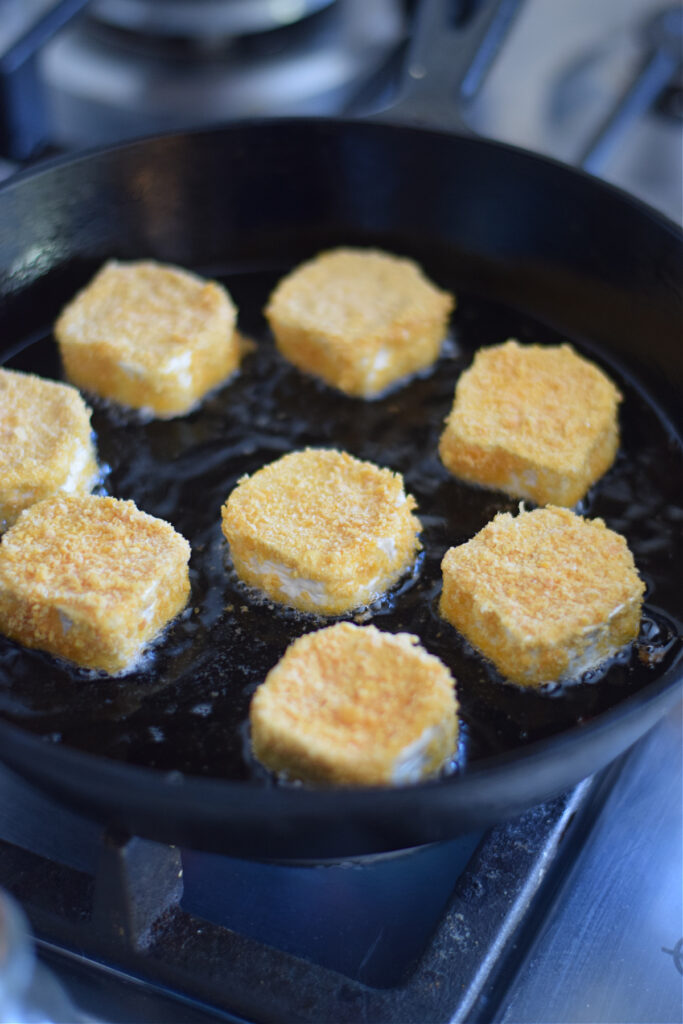 Frying goat cheese in a skillet.