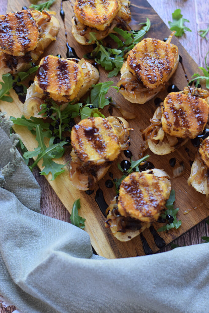 Goat cheese bruschetta on a wooden board.