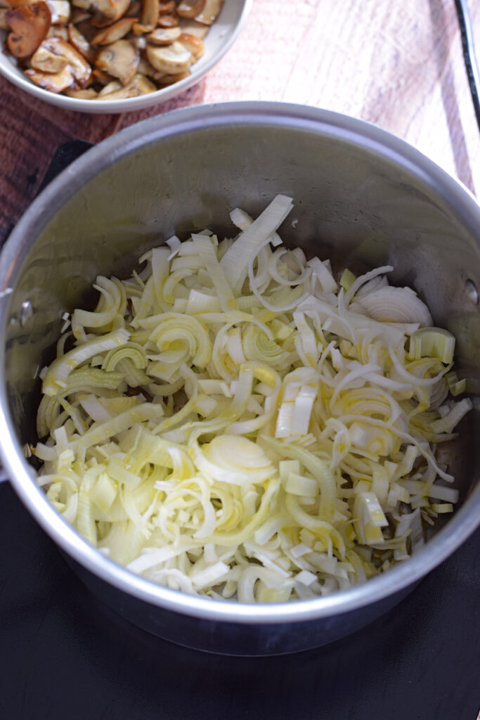 Adding leeks to a saucepan.