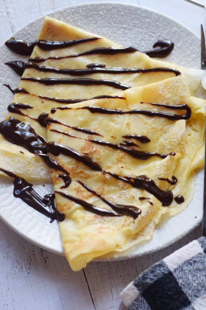 Chocolate dessert crepes on a plate.