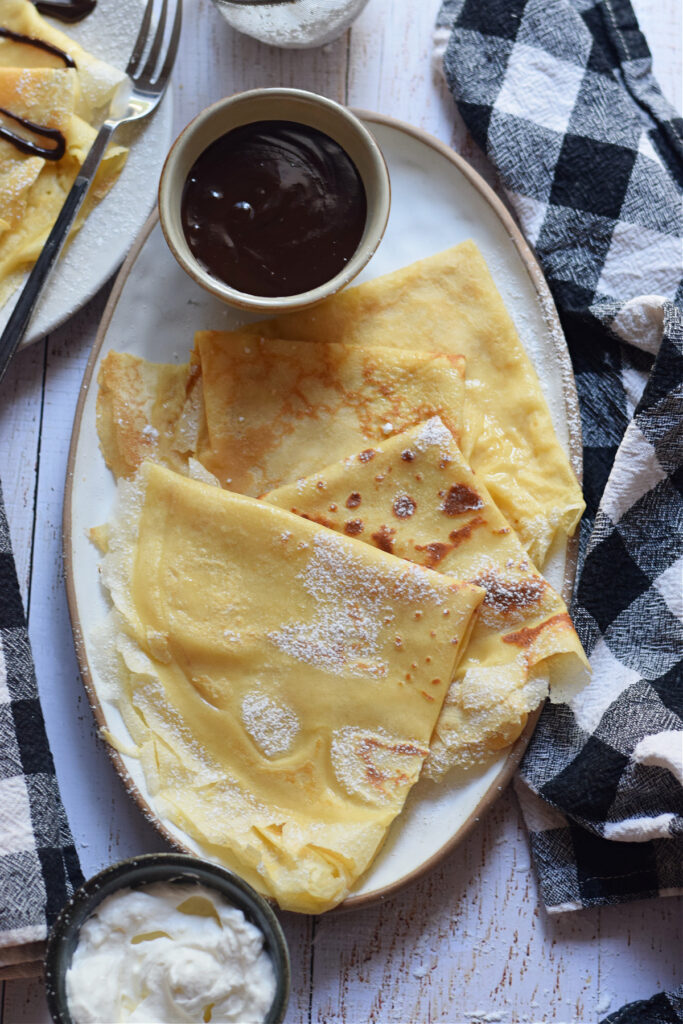 Crepes on a plate with chocolate ganache.