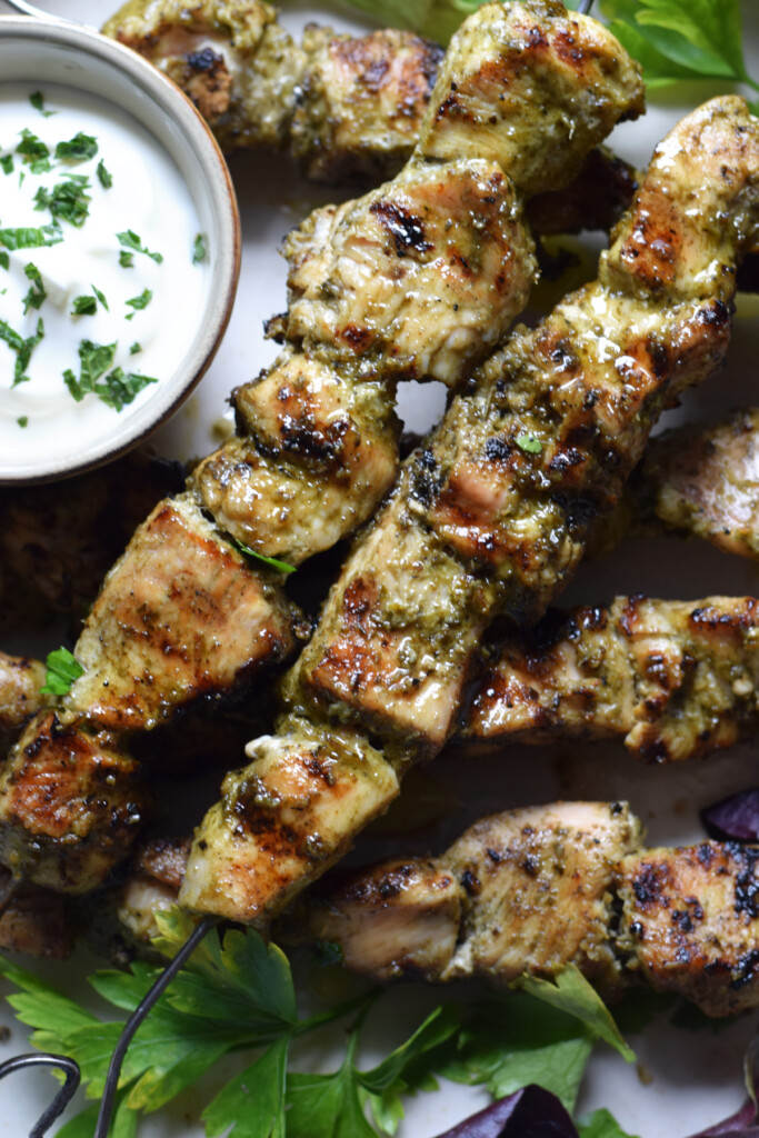 Close up of chicken kebabs with a dip.