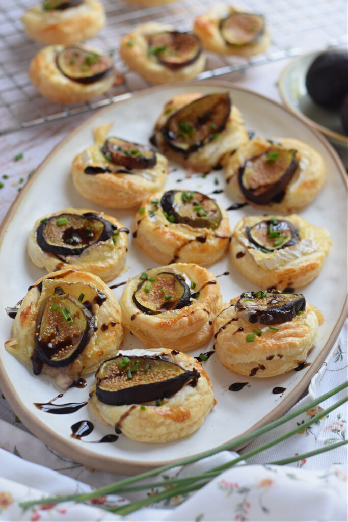 Fig and brie appetizers on a white plate.