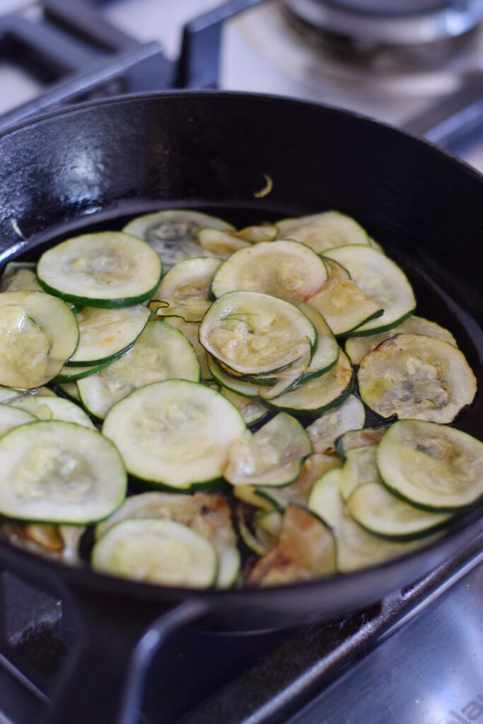Cooking zucchini in a cast iron skillet.