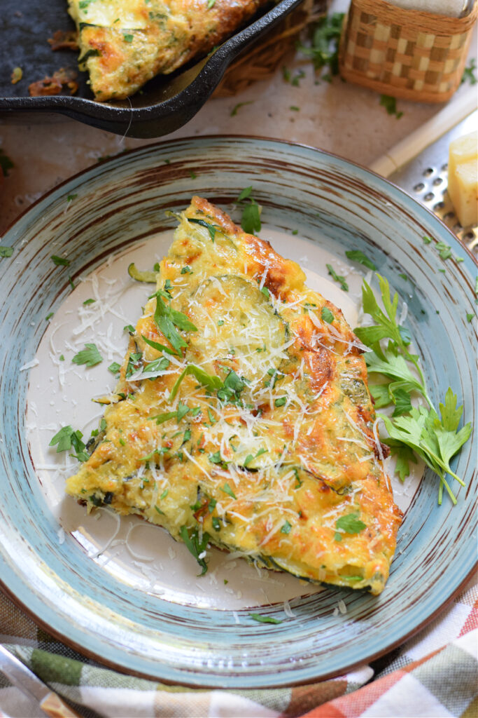 Close up of zucchini frittata on a blue plate.