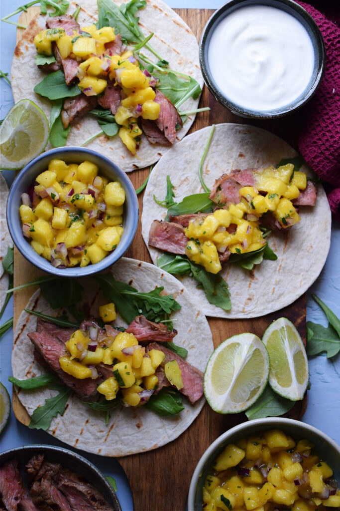 Overhead view of steak tacos with mango salsa.