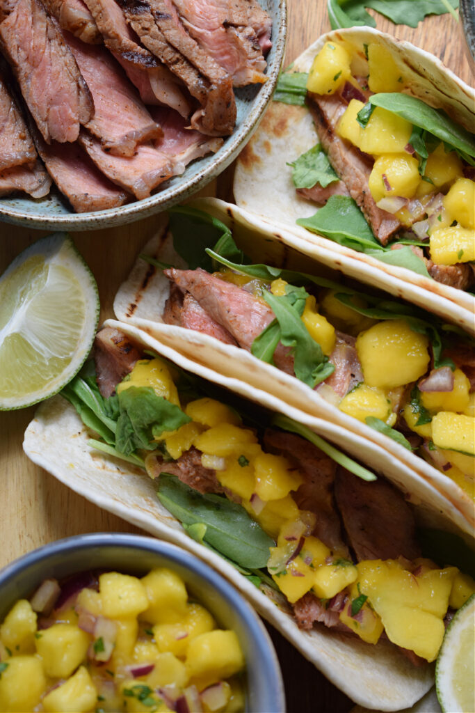 Close up of steak tacos with mango salsa.