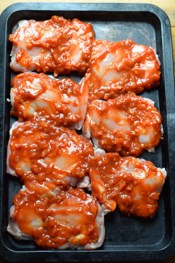 Ready to bake chicken thighs on a baking tray.