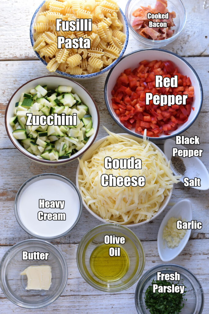 Ingredients to make pasta bake with bacon and zucchini.