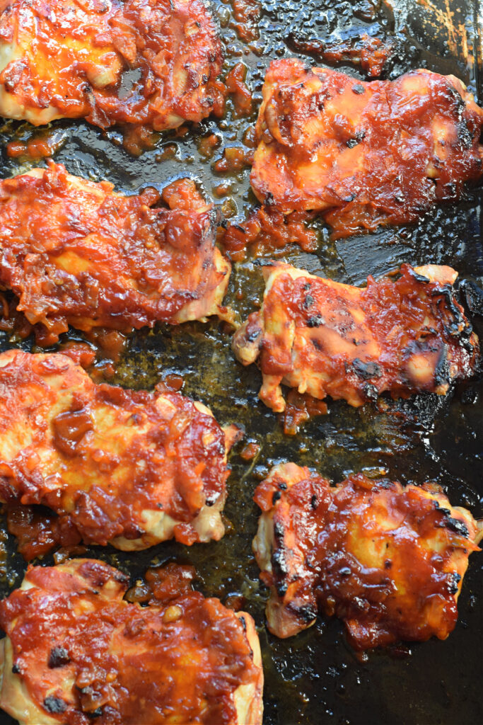 Oven baked chicken thighs on a baking tray.