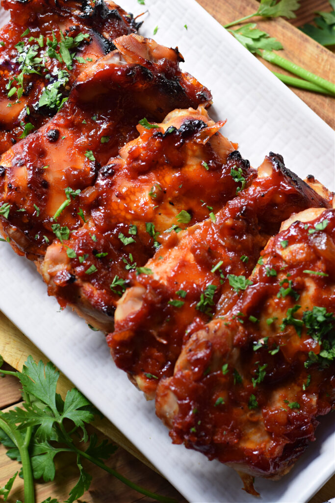 Oven barbecue chicken thighs on a plate.