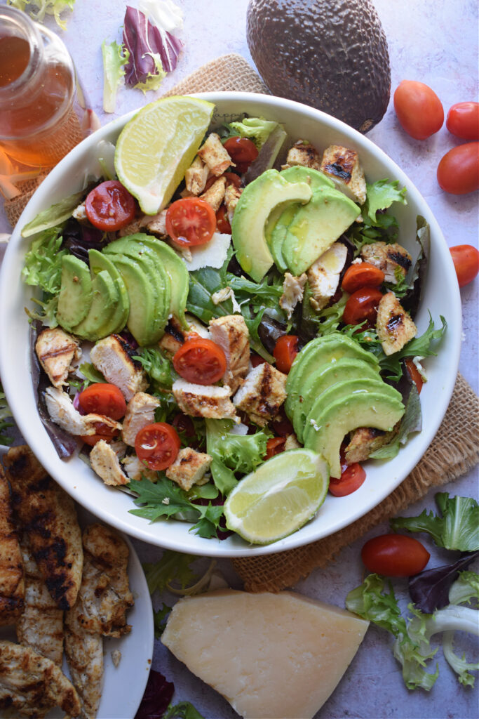 Chicken salad in a bowl with tomatoes and avocados.