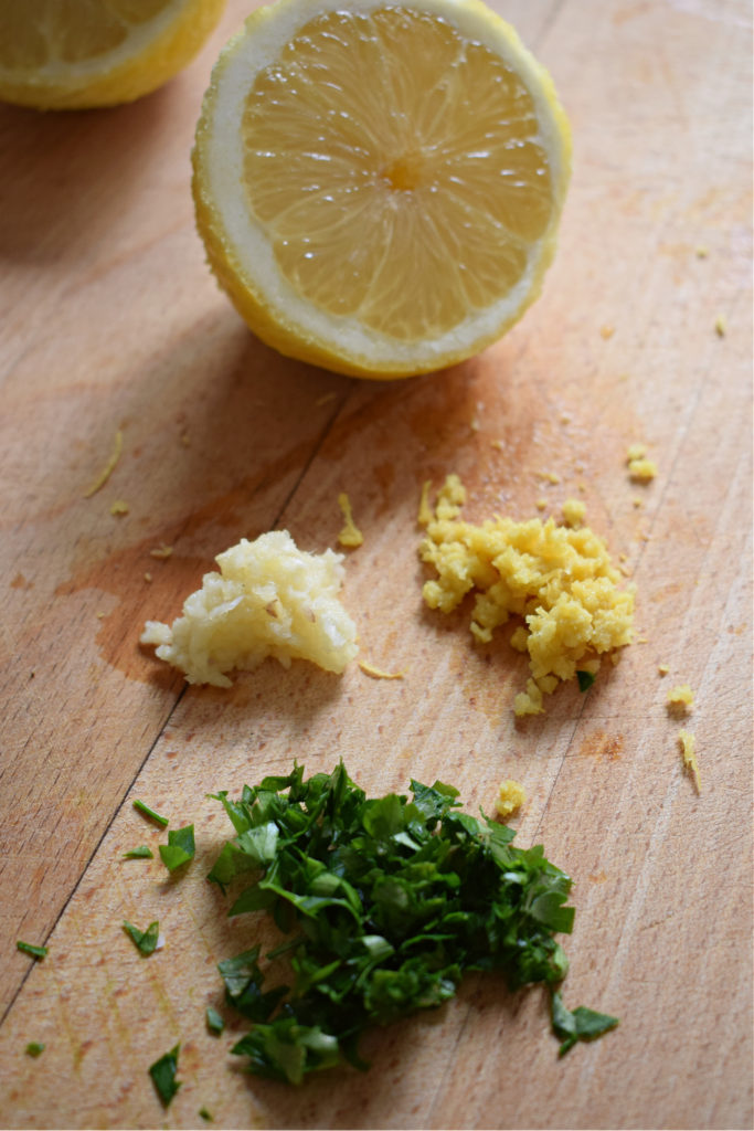 lemon, parsley, garlic and zest on cutting board