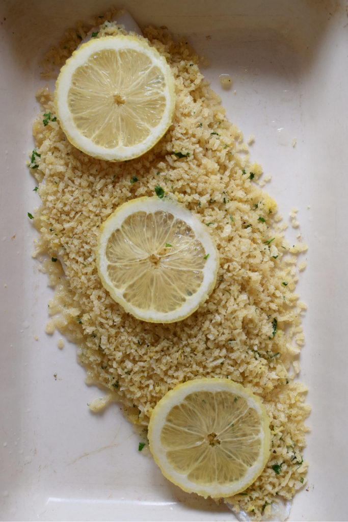 cod in a dish with lemons ready to bake