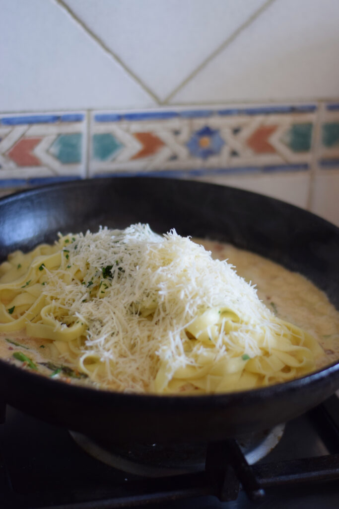 Making a pasta dish in a skillet.