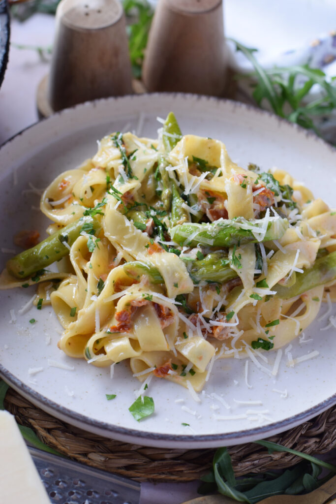 Sun dried tomato tagliatelle on a white plate.