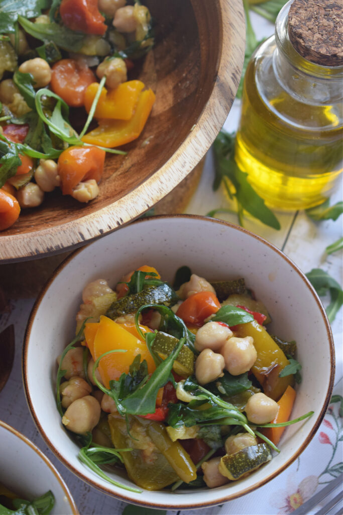 Warm mediterranean salad in a white bowl.