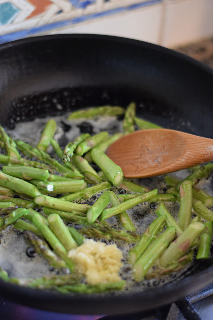 Cooking asparagus in a skillet.