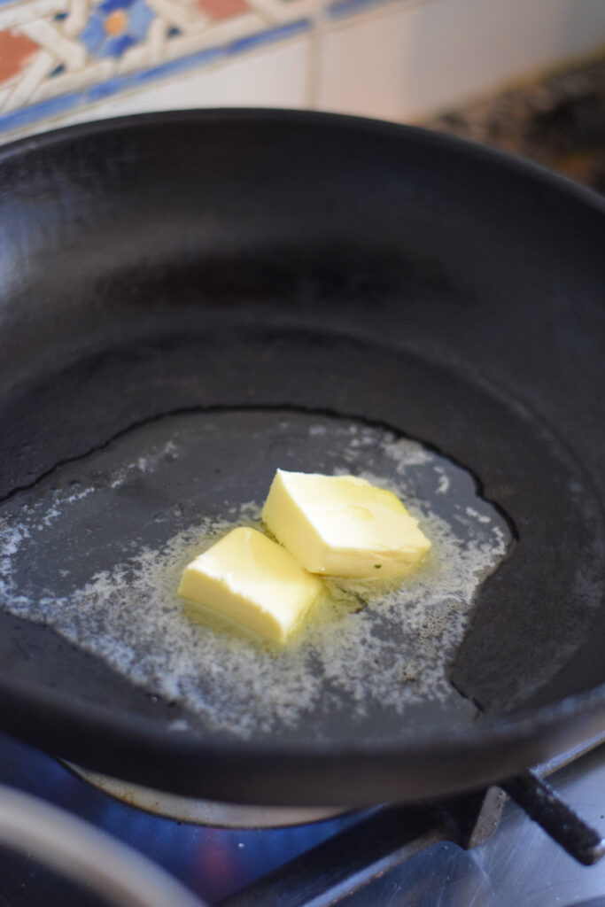Adding butter and olive oil to a large skillet.