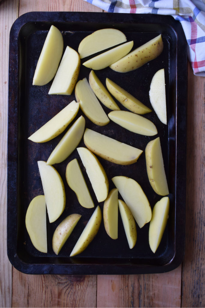 sliced potatoes on a baking tray