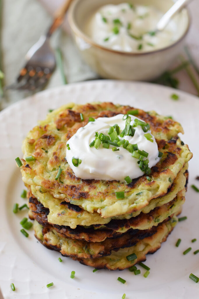 A stack of zucchini fritters with Greek yogurt.