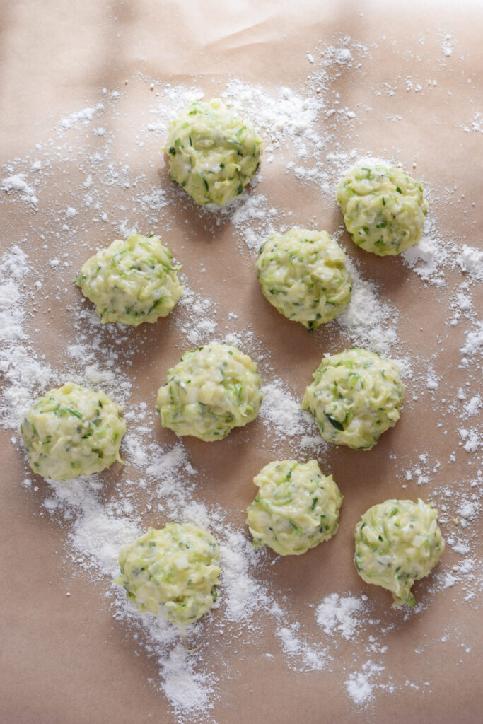 Ready to cook zucchini fritters on parchment paper.