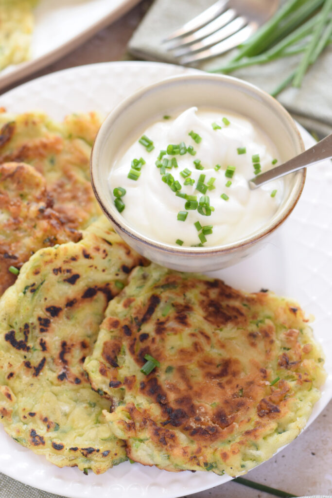 Close up of zucchini fritters with a dip.