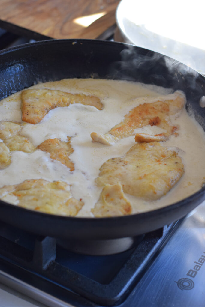 Cooking chicken in a lemon cream sauce.