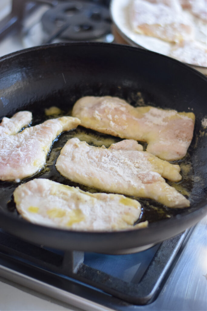 Cooking chicken cutlets in a skillet.