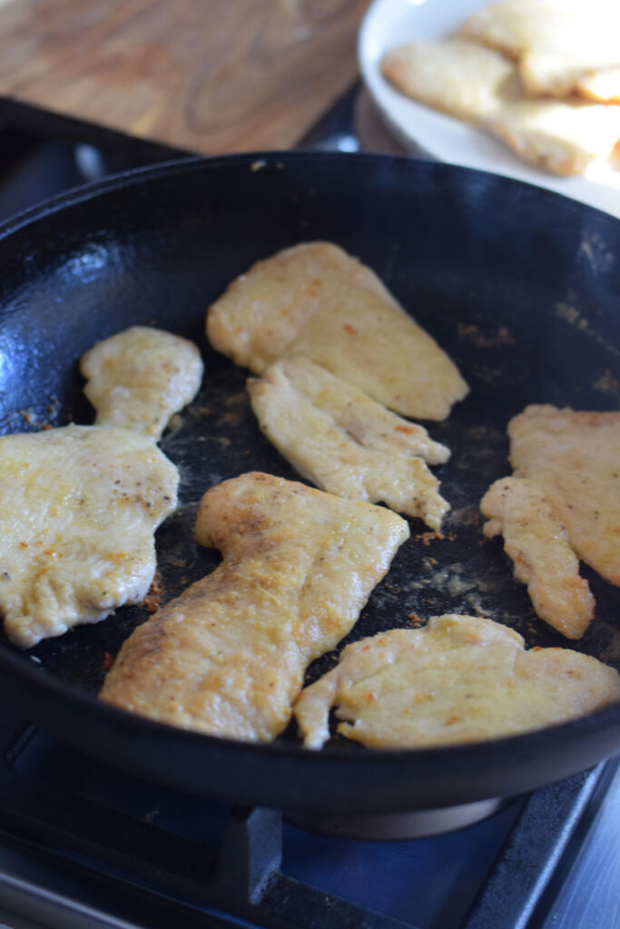 Cooking chicken cutlets in a skillet.