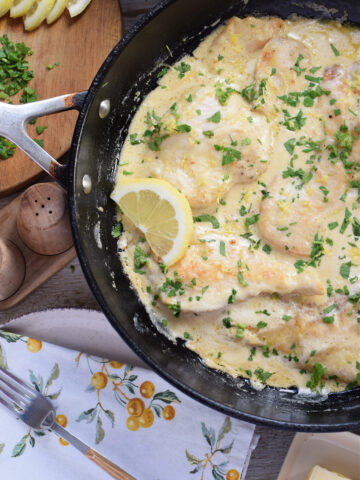 Chicken in a lemon cream sauce in a skillet.