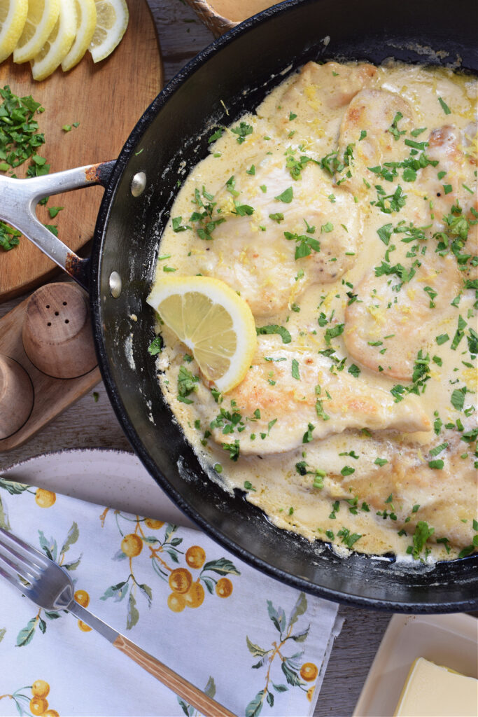 Chicken in a lemon cream sauce in a skillet.