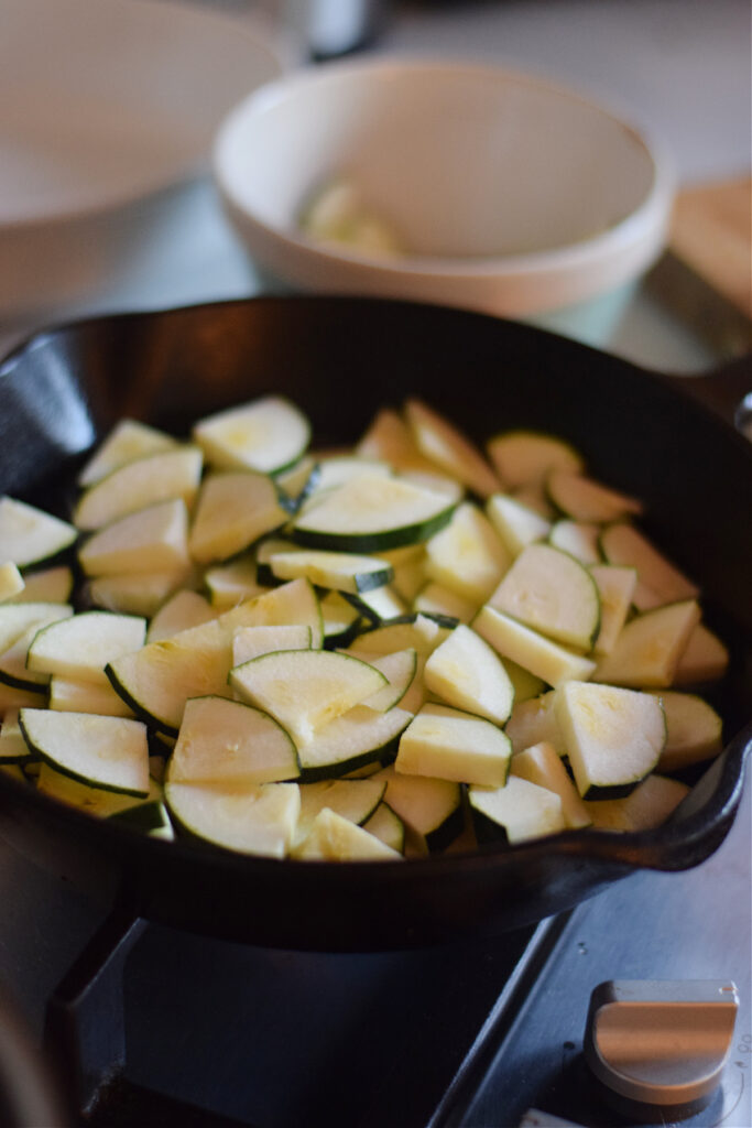 Cooking zucchini in a cast iron skillet.