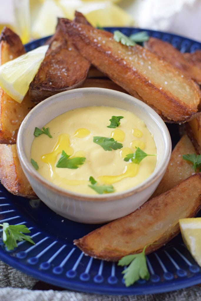 Close up of a sauce in a small dish with parsley garnish on top.