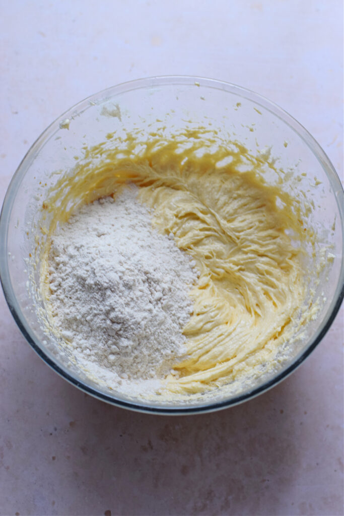 Adding flour to the cake batter.