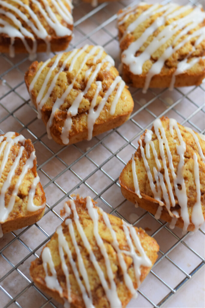 Cinnamon cake squares on a cooling rack.