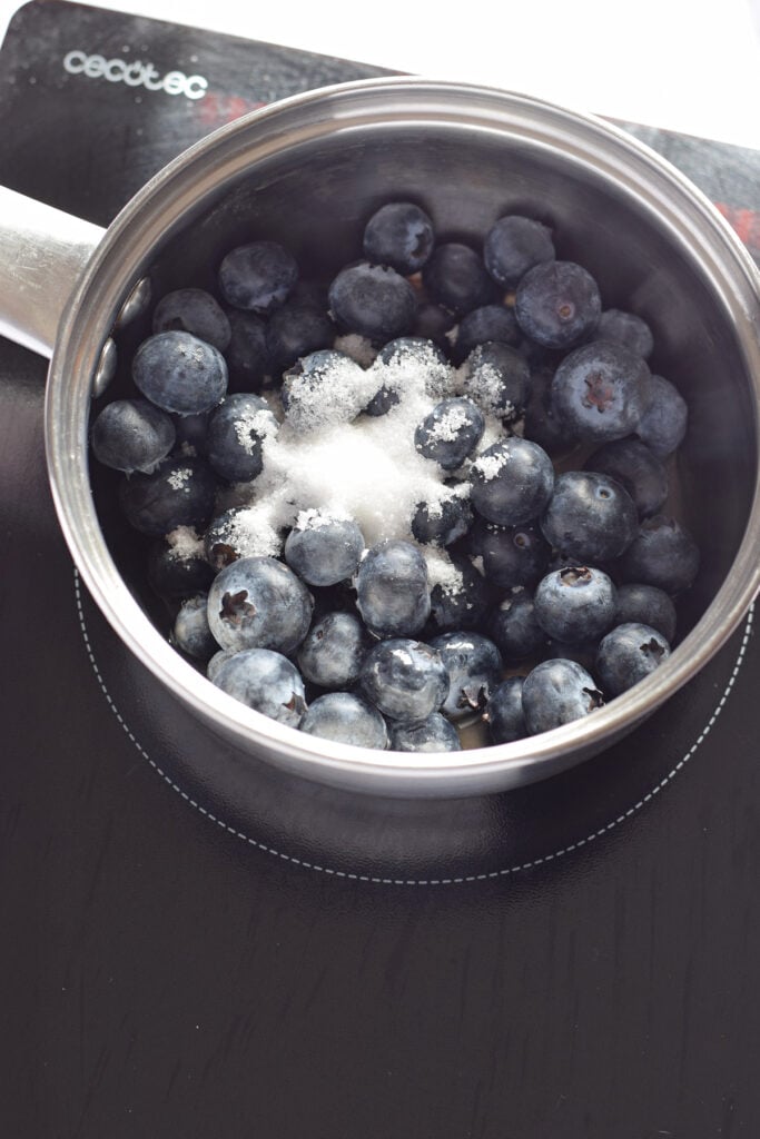 Cooking blueberries in a saucepan.