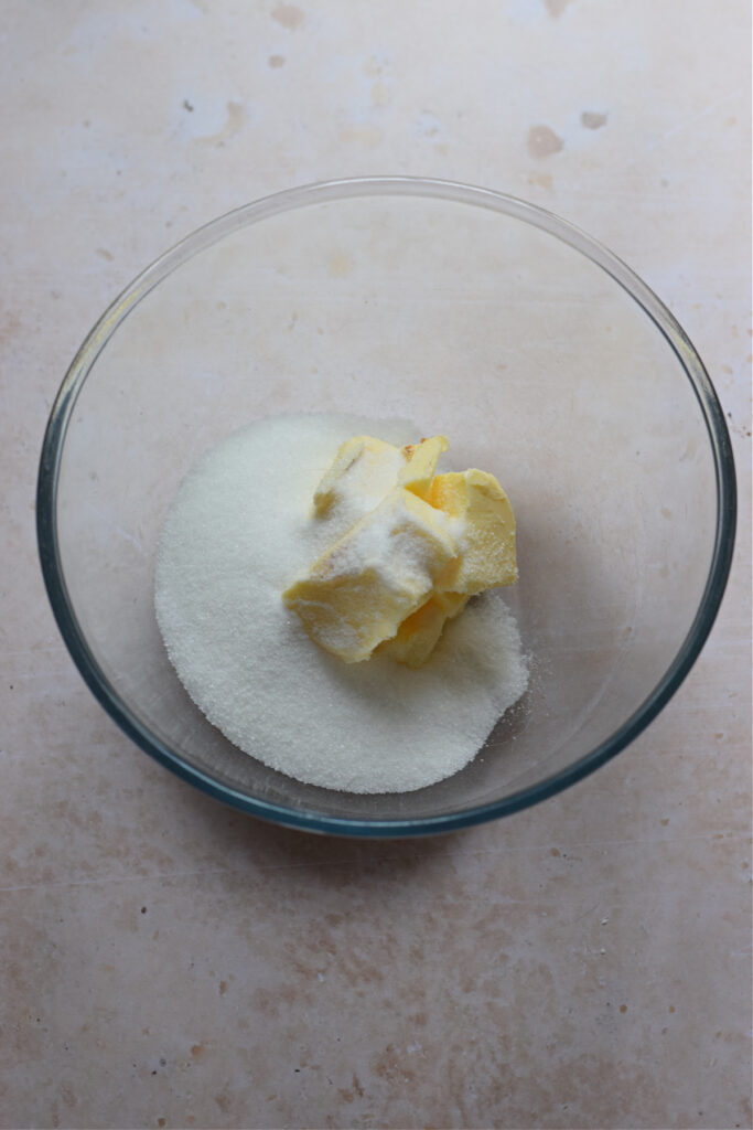 Butter and white sugar in a glass bowl.